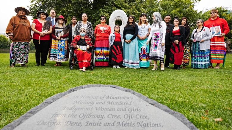 MMIWG families pose for a photo in front of a MMIWG monument. 