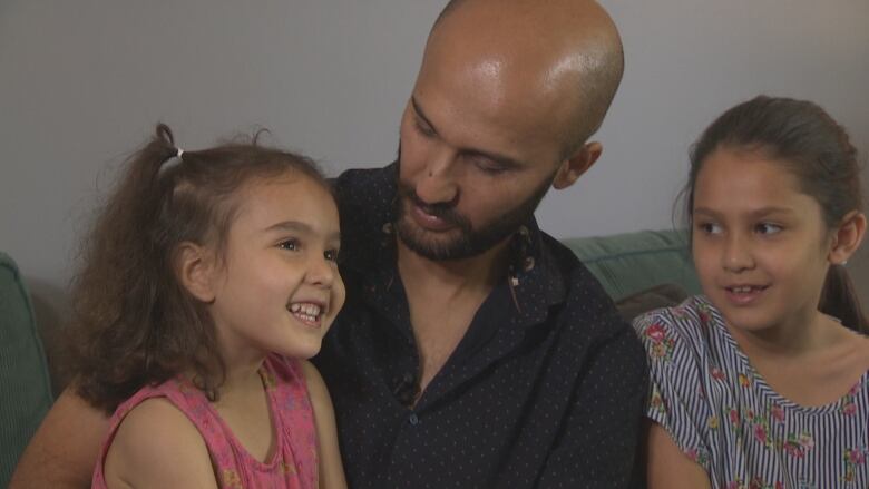 Ahmad Muslim Khuram, centre, with his two daughters.