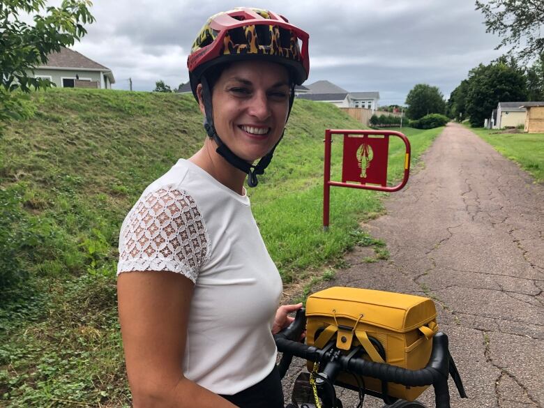 A woman wearing a bike helmet and sitting on a bike