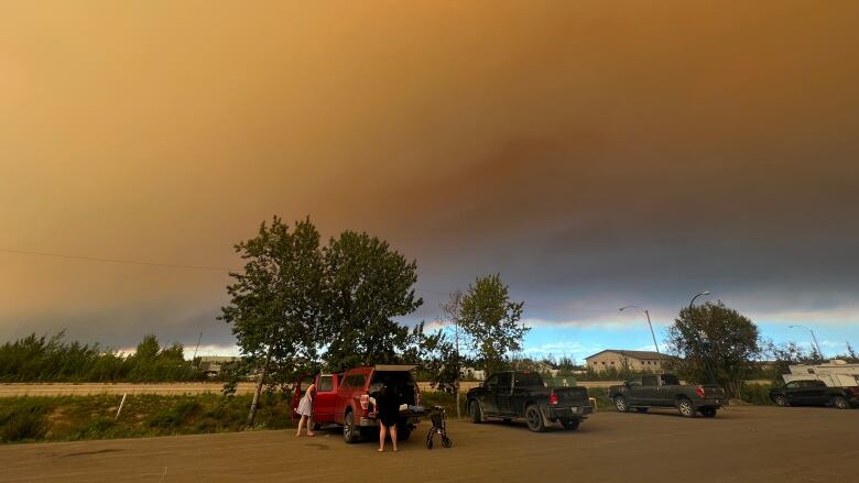 People stand under smoke