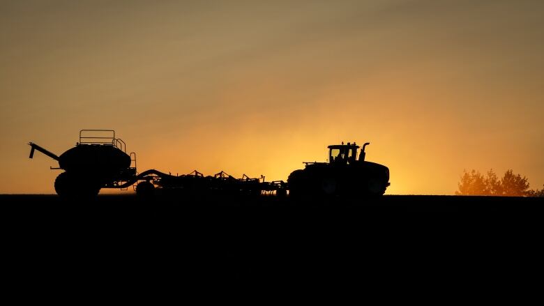 A seeder is pictured in silhouette. 