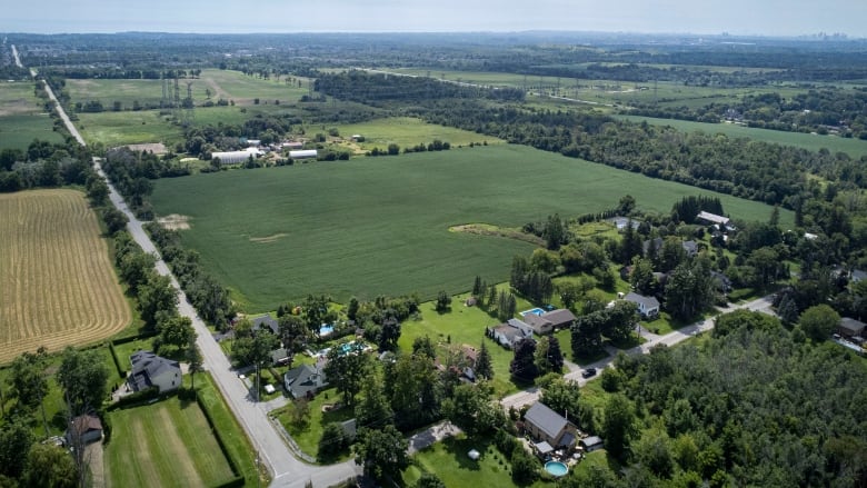 An aerial view of a small hamlet and surrounding green fields.