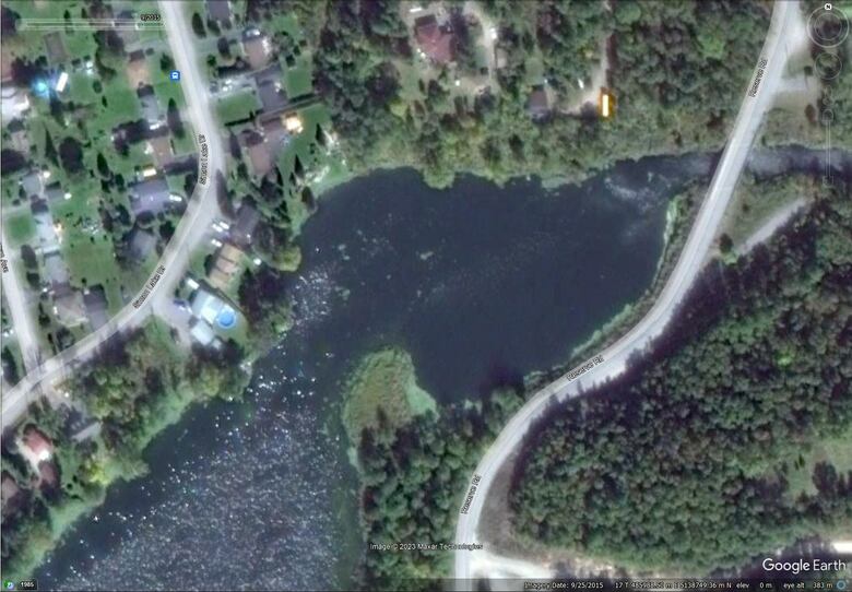 A satellite image of Simon Lake shows the development of algae along the shoreline on September 25, 2015. Algae can be seen as light shades of green.