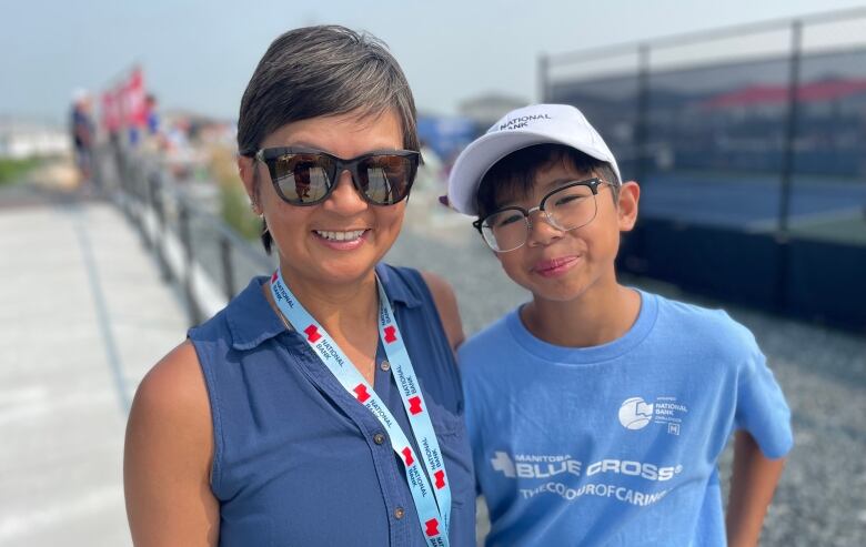 A woman and kid stand beside each other