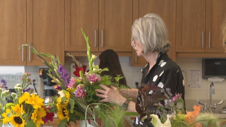 A woman arranging a bouquet of flowers