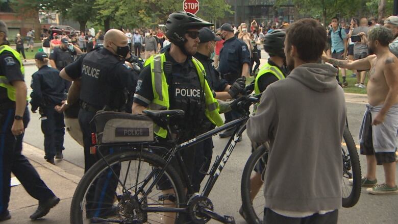 A Halifax Regional Police officer with a bicycle lifts it off the ground using the 