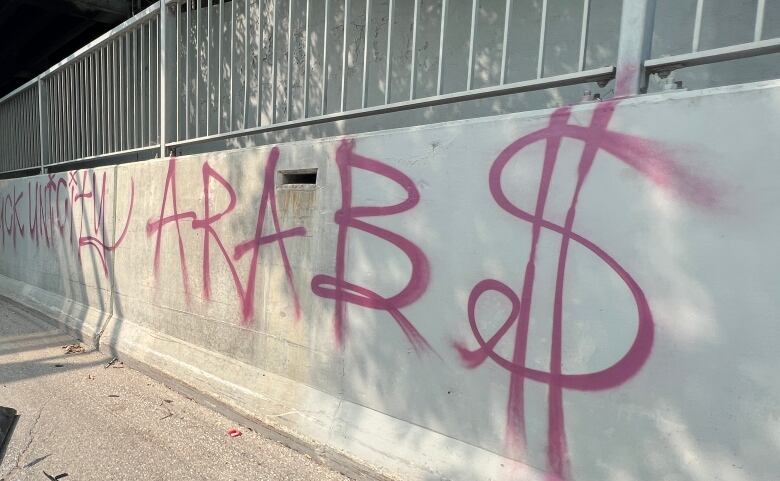 A spray-painted message with reference to Arabs, with a dollar-sign in place of the 