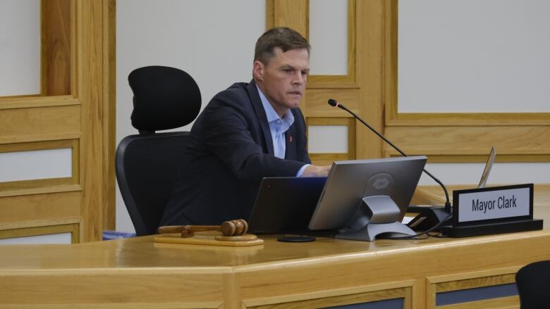 Mayor Charlie clark touch a screen in front of him on a desk