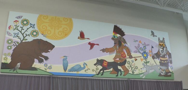 Mural depicting artistically rendered giant beaver being confronted by two men, one with a spear and another with a bow with dogs, birds and flowers surrouding them.