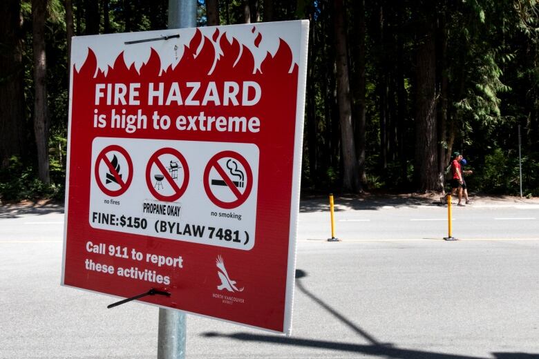 A red sign says 'FIRE HAZARD is high to extreme' and lists fire bans and no smoking.