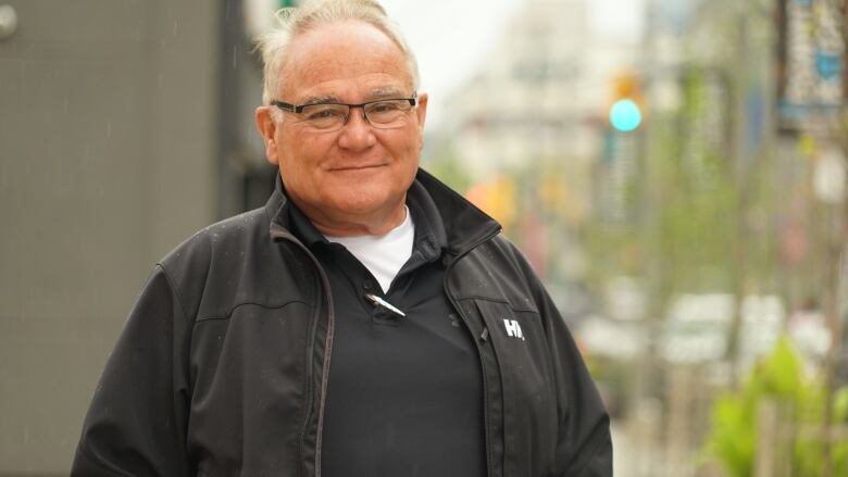 A man wearing glasses smiling.