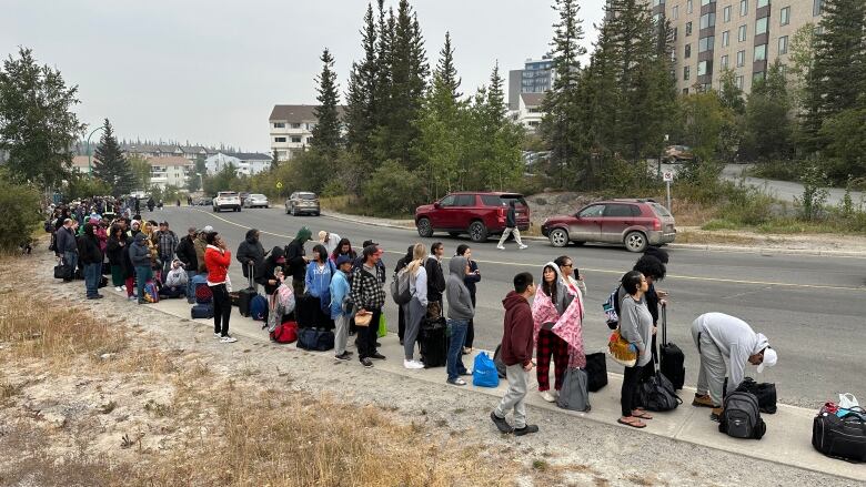 A line up of people on the street.