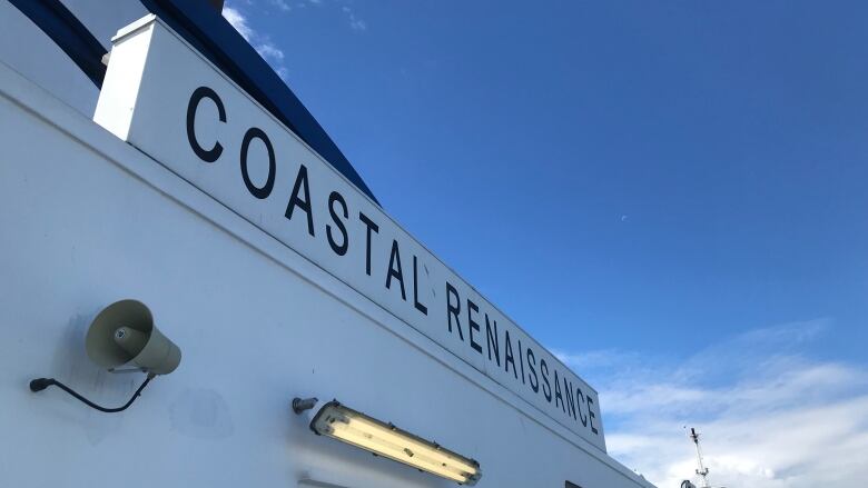 A large white ferry with the words 'Coastal Renaissance' written in blue on the site. 