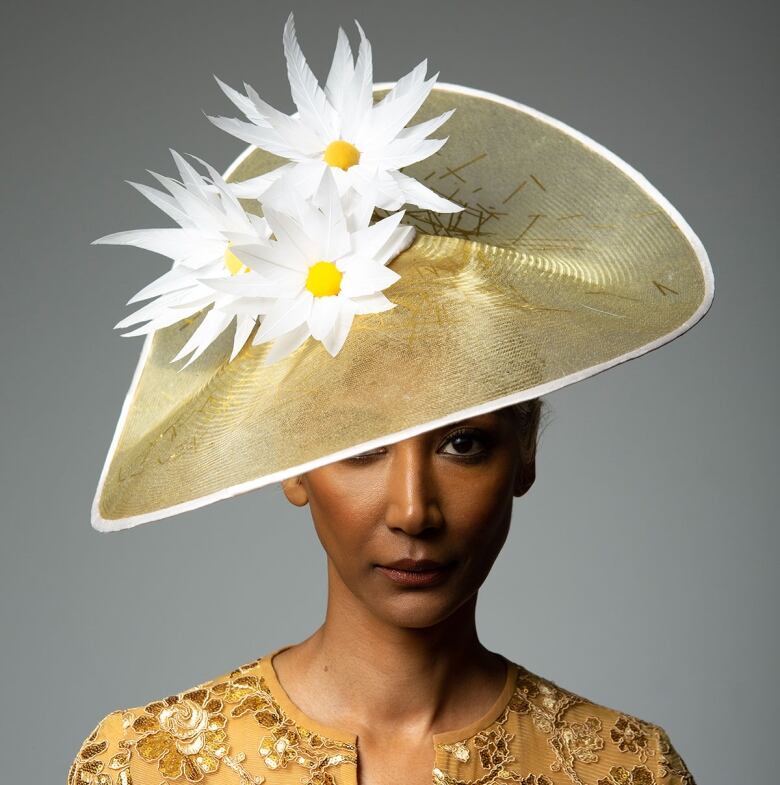 A woman wearing a large gold hat