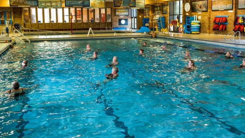 A group of swimmers in an indoor pool.