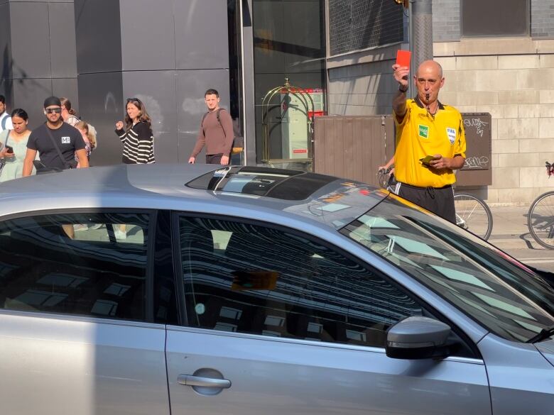 Man holds up red card at driver.