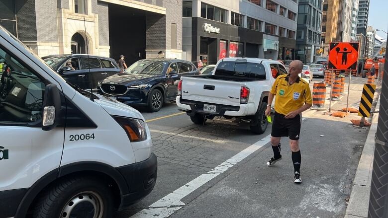 Man blows his whistle at van.