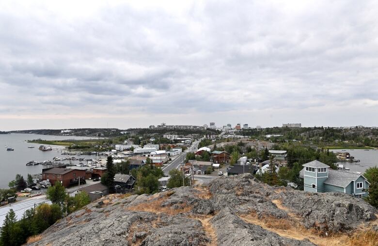 Rocks, buildings, lake, cloudy sky.