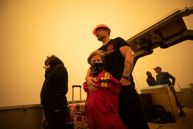 A man hugs his daughter.