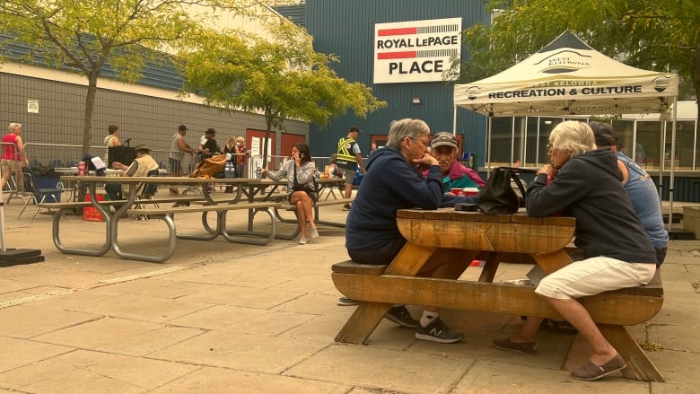 People sit at tables outside.