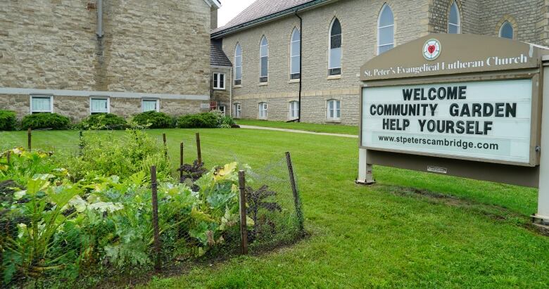 photo of the front of a church with a community garden on the lawn.