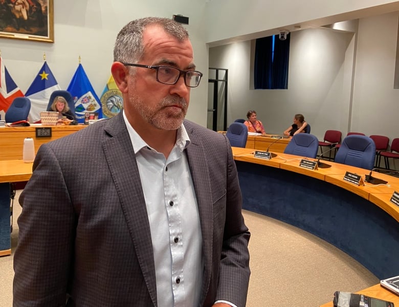 A man wearing a shirt and suit jacket in Fredericton council chambers.