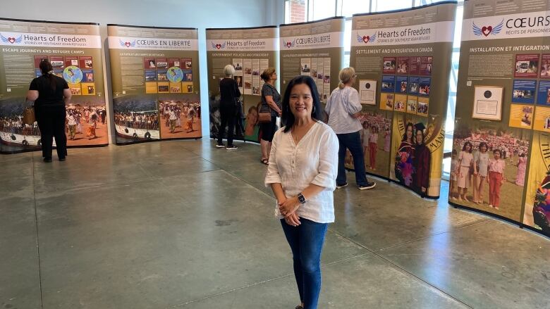 A woman poses in front of a museum display and smiles at the camera.