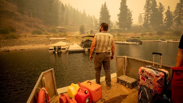 A man prepares to return to his home in Lee Creek with supplies after crossing Shuswap lake to Lee Creek from Sorrento, British Columbia on Saturday, August 19, 2023.