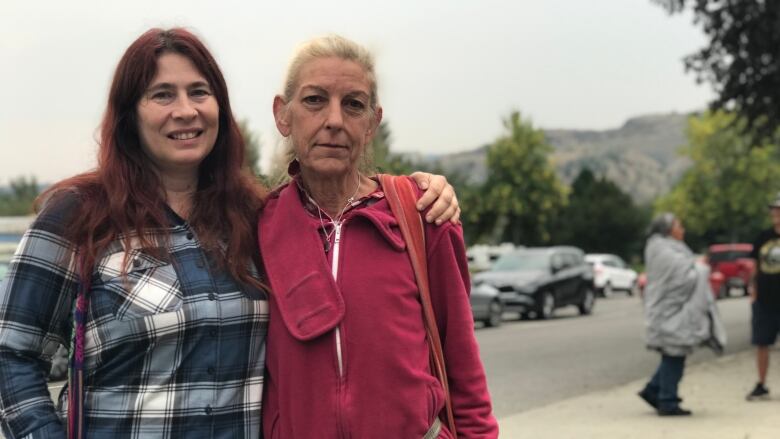 Two women stand outside with their arms around each other in Kamloops, B.C.