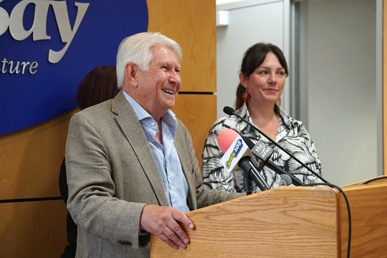 A man smiles behind a podium.