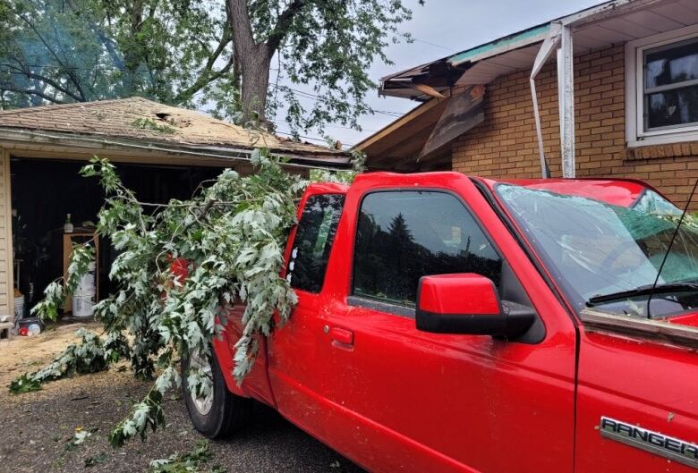 A pickup truck, house and garage in Windsor are shown after sustaining damage in Thursday night's storm.