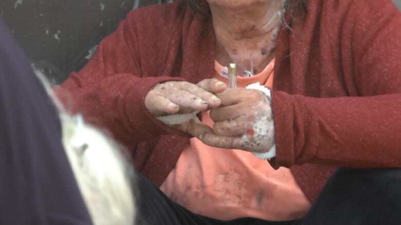 A pair of hands hold a pipe.