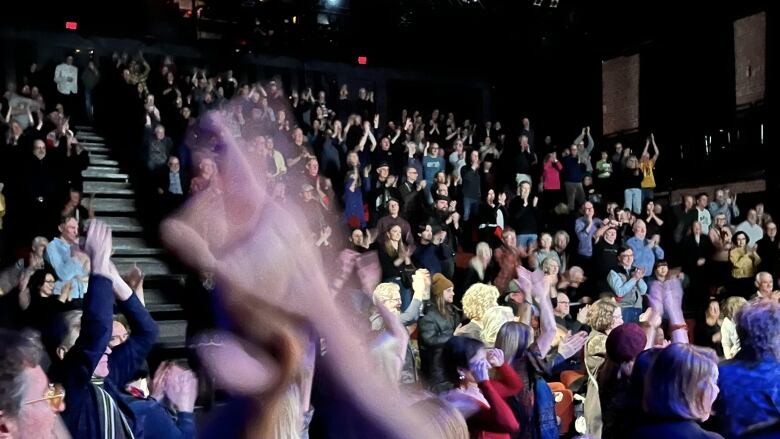 A theatre audience applauding.