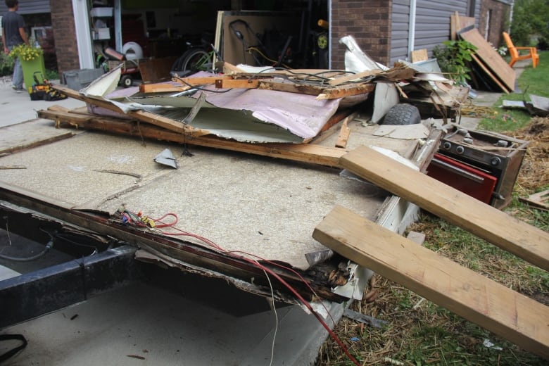 Piles of wood and metal in a driveway. 