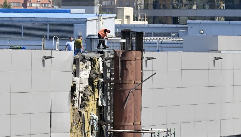 Investigators examine drone strike-related damage at an exhibition hall in a Moscow business district.