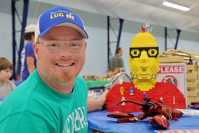 Shawn sits beside of Lego self-portrait. 