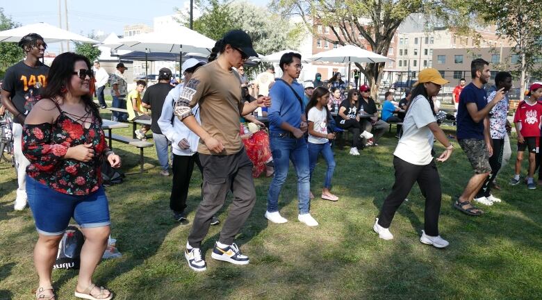 People are shown dancing in a field.