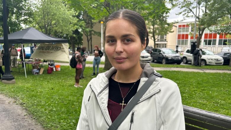 A woman poses for a photo in a park.