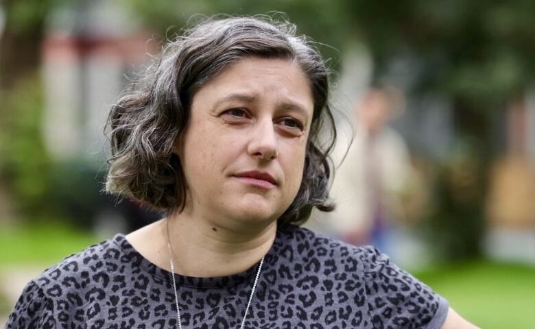 A woman stands in a park.