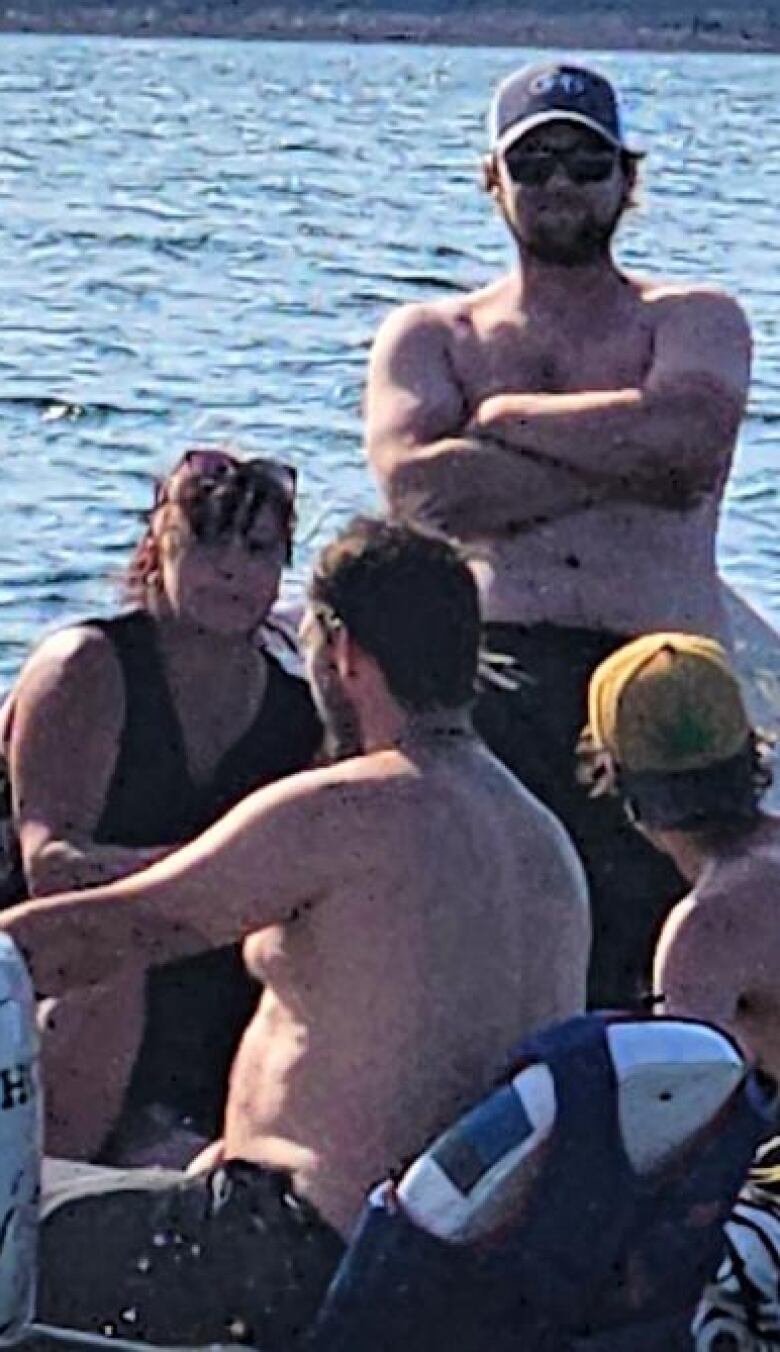 Three women and a man sit in a small motorboat as it moves through the water