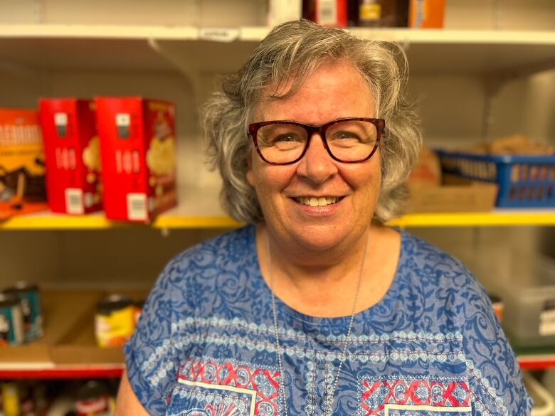 Susan Kidd, standing in front of shelves with food on them. She runs the food bank at the University of Prince Edward Island.