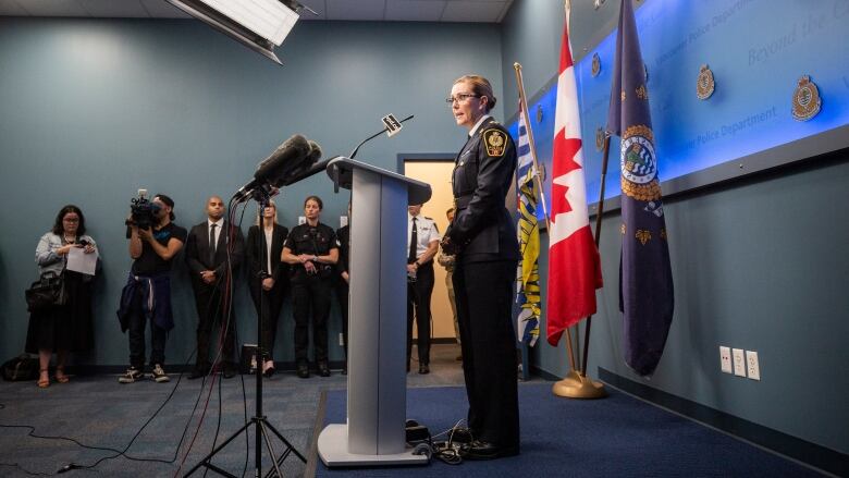 A white woman wearing a police uniform speaks at a press conference.