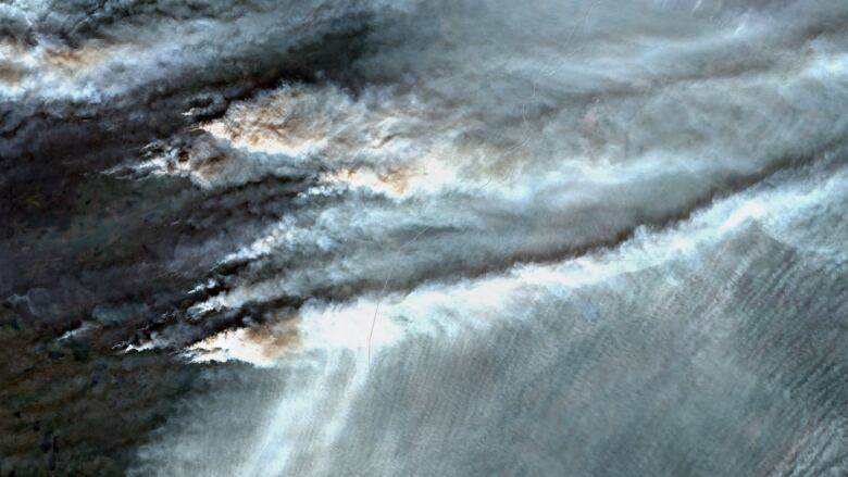 Satellite imagery shows billowing smoke from wildfires.