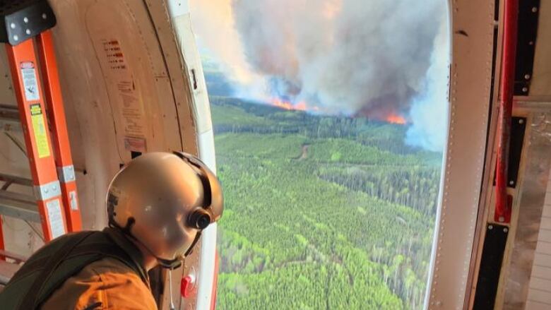 A firefighter with the B.C. Wildfire Service observes the Donnie Creek wildfire from a plane in this undated photograph. The fire has been burning since May 12, 2023. It was estimated to be 5831 square kilometres in size on Aug. 28.