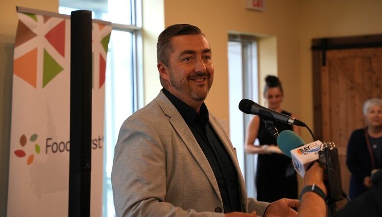 A smiling man stands at a podium.