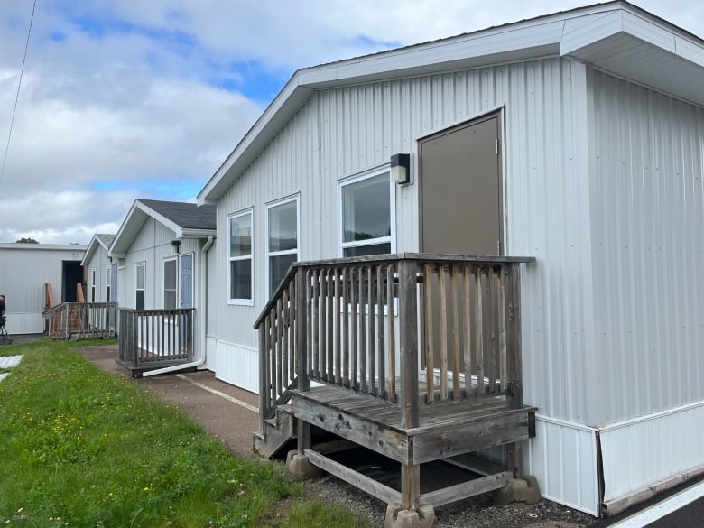 One-storey buildings with wooden staircases leading to doors. 