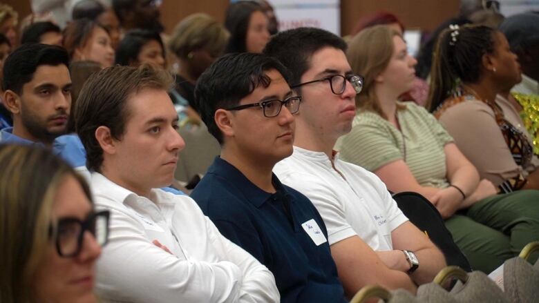 A group of people sitting in a hall.