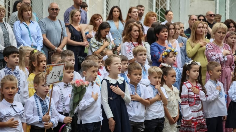 Children sing the Ukrainian national anthem on the first day of school in Kyiv.