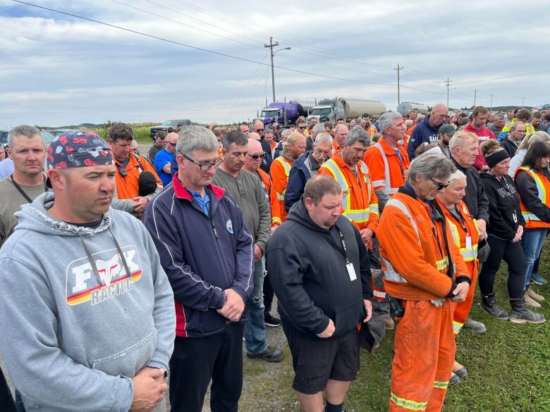 Group gather with heads down.