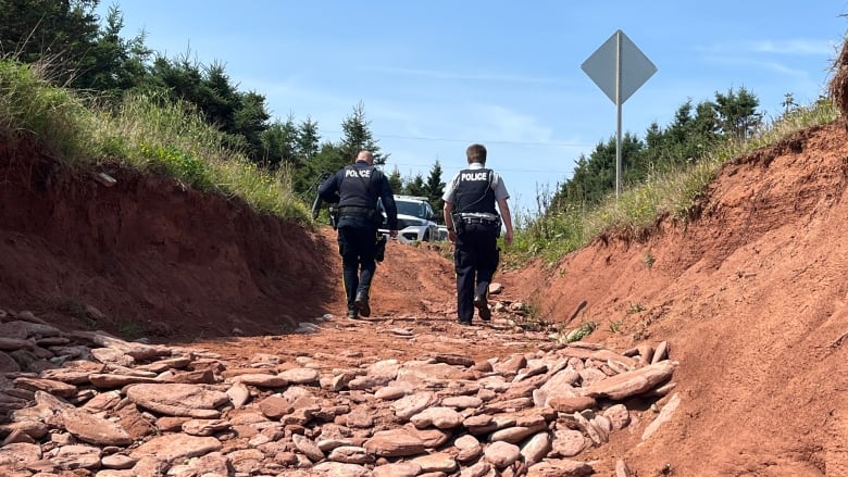 RCMP walking on beach.